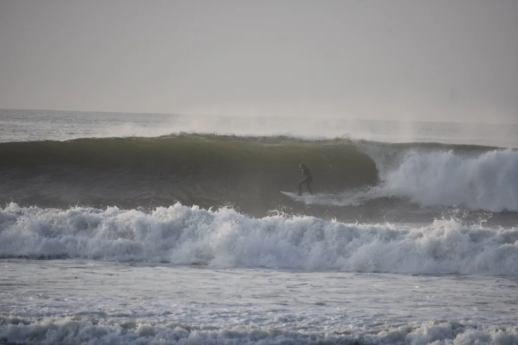 - Sebago Technics A surfer rides a large wave under a gray, overcast sky, as foamy waves crash in the foreground—much like the powerful force behind a Maine engineering firm.